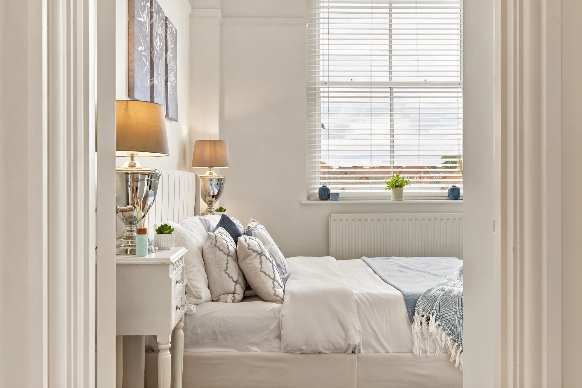 Barrington Grange bedroom viewed through the doorway with layered bedding and bedside lamps