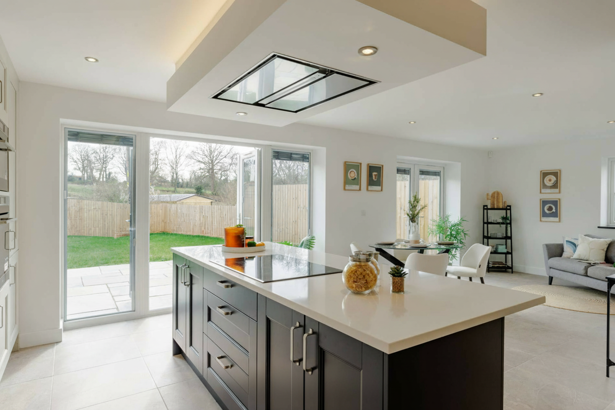Staged open-plan kitchen with island and garden view
